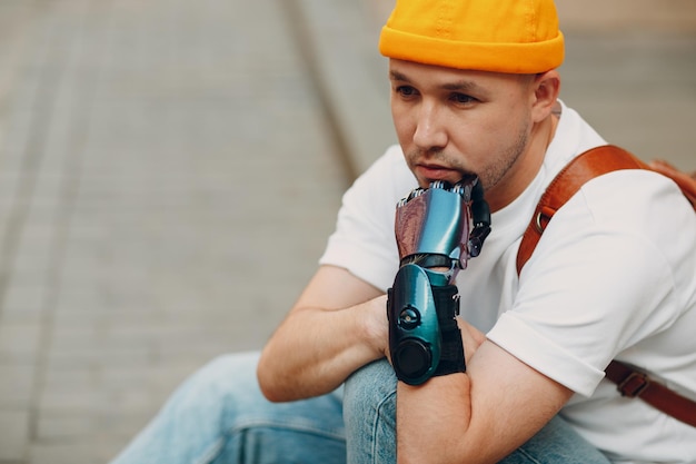 Young disabled man with artificial prosthetic hand in casual clothes