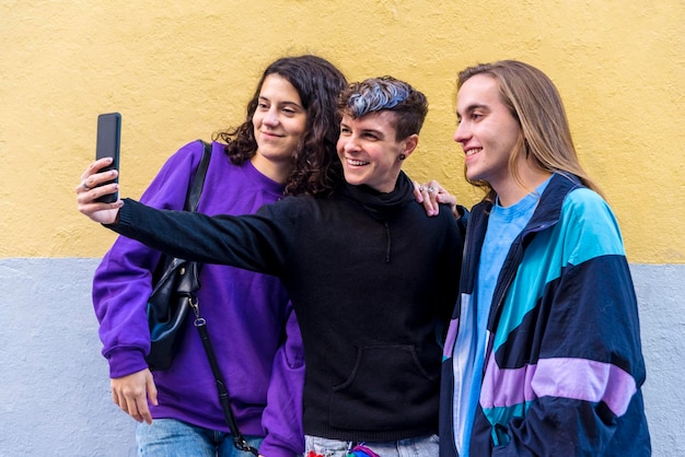 Photo young diverse friends taking selfies with a mobile phone outdoors