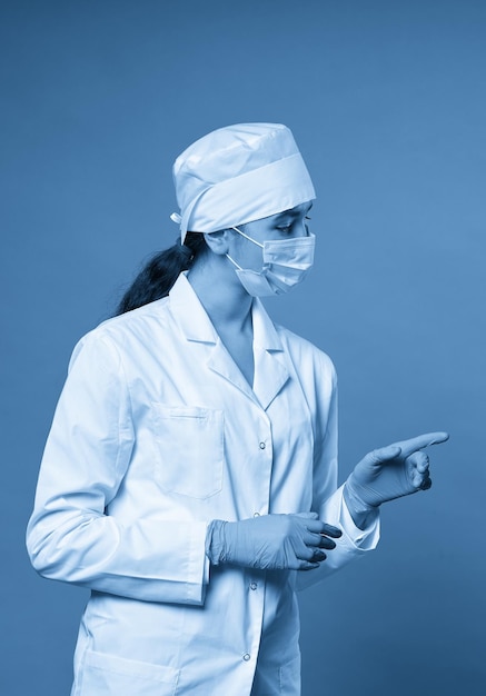 Young doctor against dark blue background studio shot with copy space