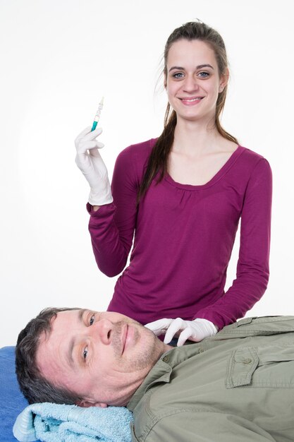 Young doctor applying injection on face