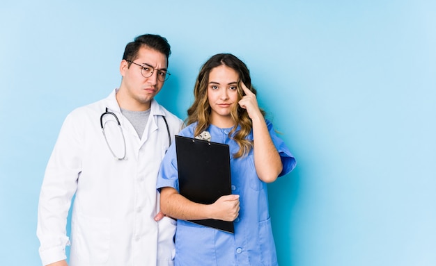 Young doctor couple posing in blue