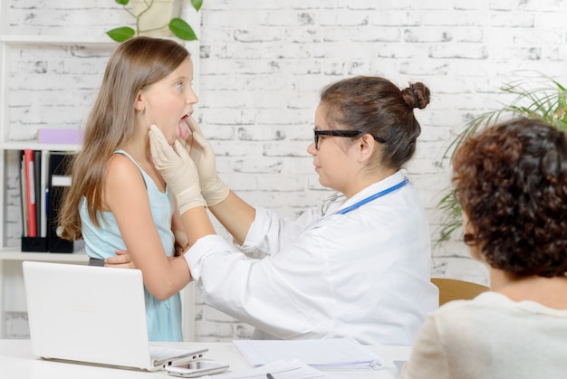 Young doctor examines a little girl