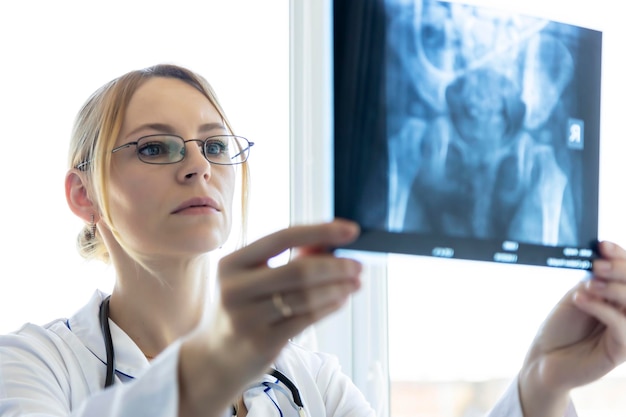 A young doctor examines an Xray image of a sick patient Focus on the doctor Orthopedic department