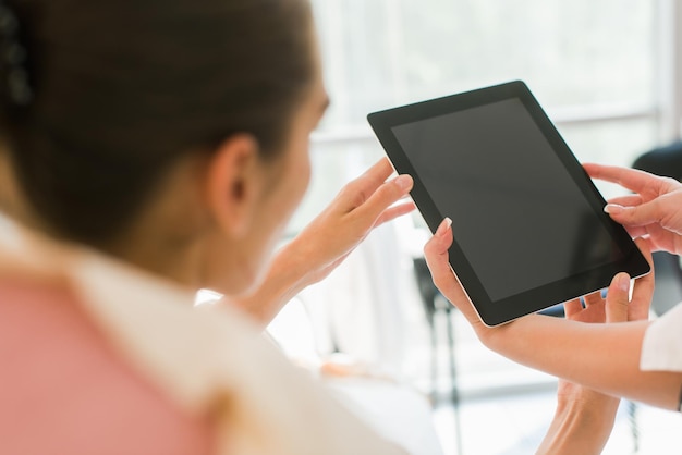 Young doctor holding a tablet and talking to her patient. Woman and doctor before surgery.