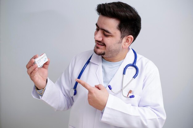 Foto un giovane medico tiene la medicina in una mano e mostra con il dito