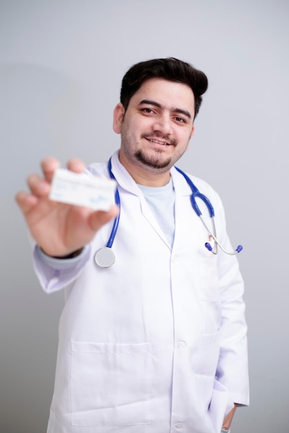 A young doctor is standing and holding medicine in hand