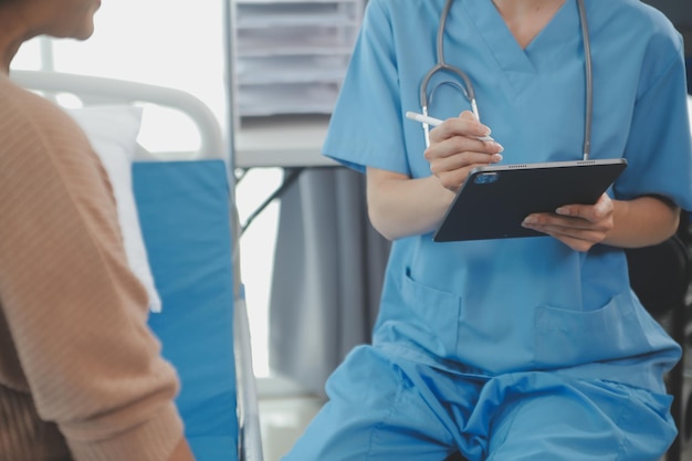 Young doctor is using a stethoscope listen to the heartbeat of the patient Shot of a female doctor giving a male patient a check up