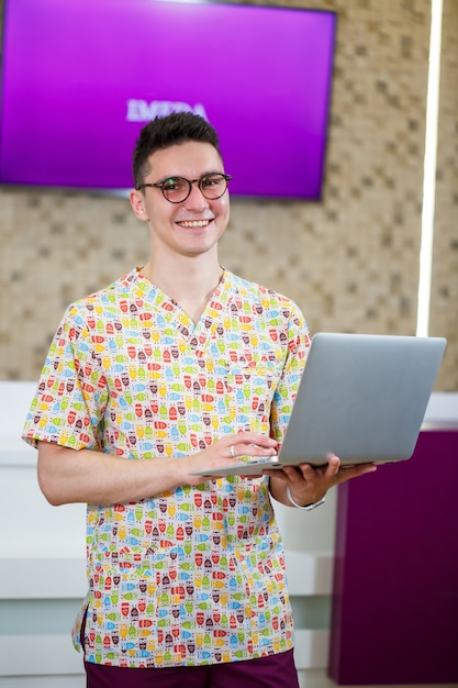 A young doctor is working on a laptop on a dissertation. the doctor in the clinic conducts online patient reception