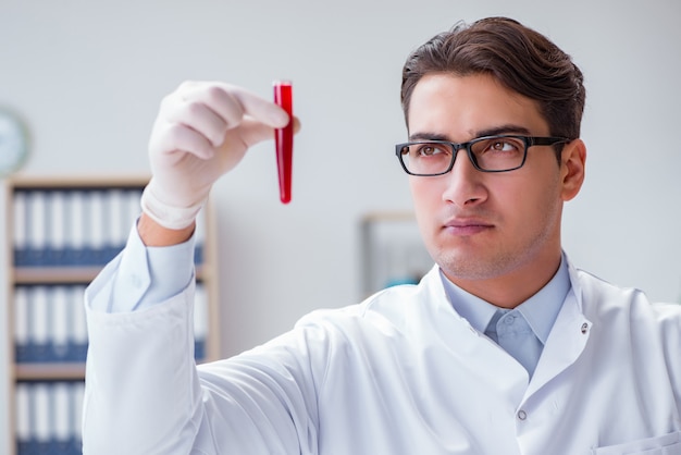 Young doctor in the lab with red tube