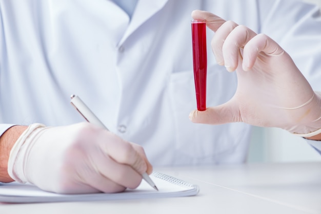 Photo young doctor in the lab with red tube