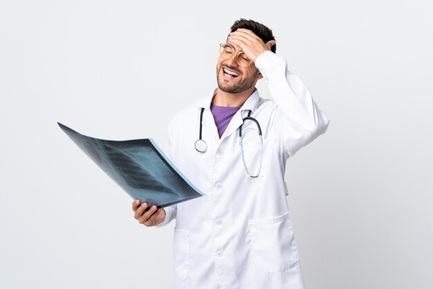 Young doctor man holding a radiography isolated laughing