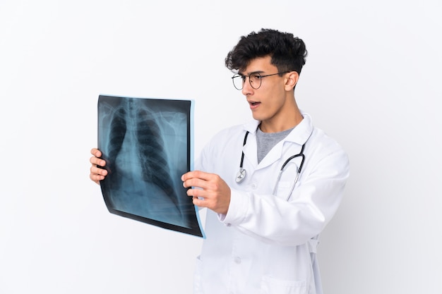 Young doctor man over isolated wall