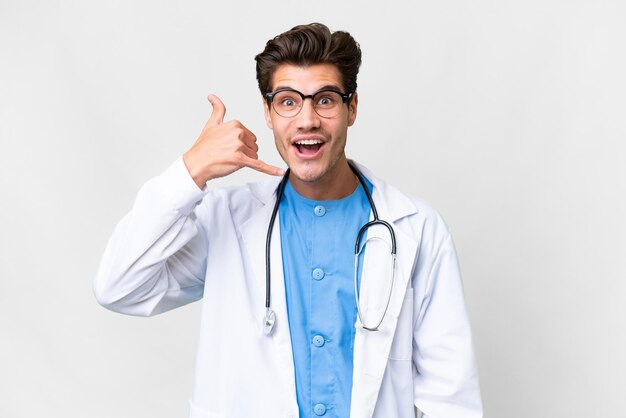 Young doctor man over isolated white background making phone gesture Call me back sign