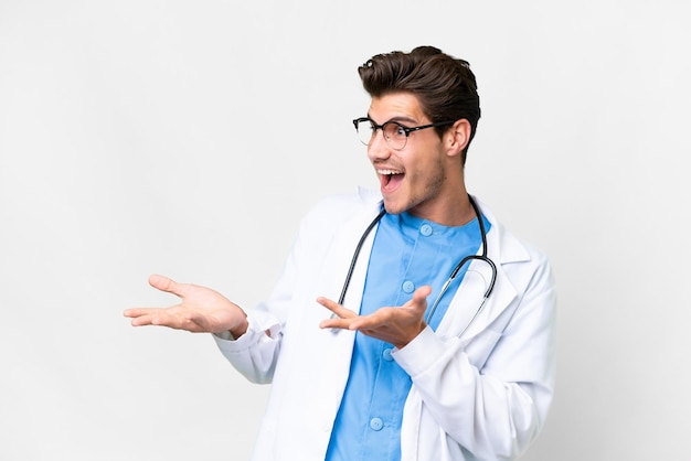 Молодой врач на изолированном белом фоне с удивленным выражением лица