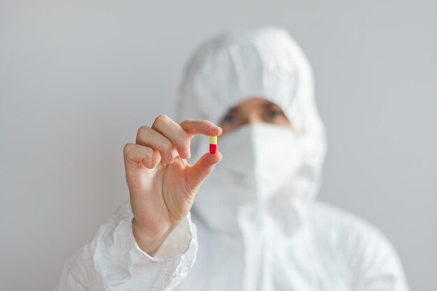 young doctor. medical mask, white coat. background. syringe, vaccine vial glass bottle. vaccination