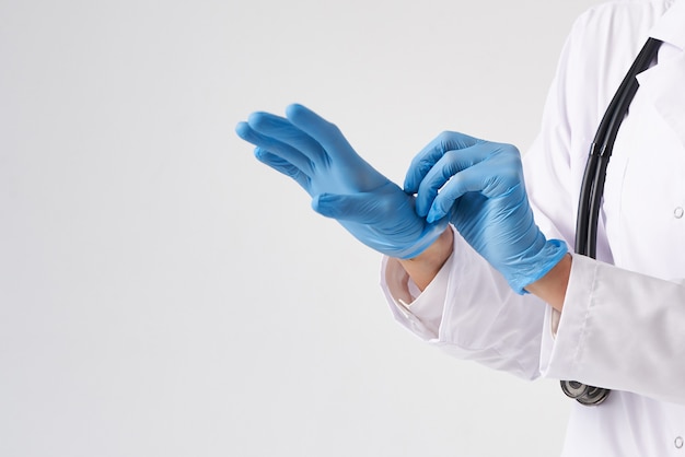 Young doctor putting on surgical gloves