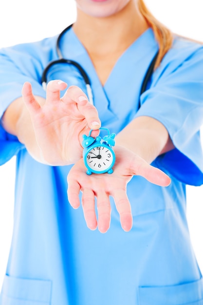 Foto un giovane dottore che mostra l'orologio su sfondo bianco