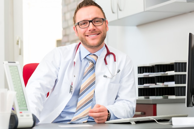 Young doctor sitting in surgery at desk