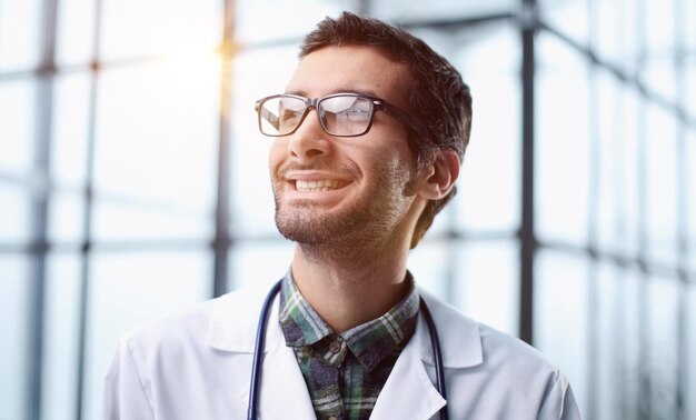 A young doctor stands alone in the studio and poses for the camera