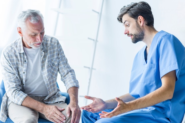 Young doctor talking to senior patient