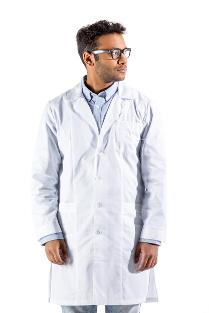 Photo young doctor in white coat gesturing and looking at camera isolated on white