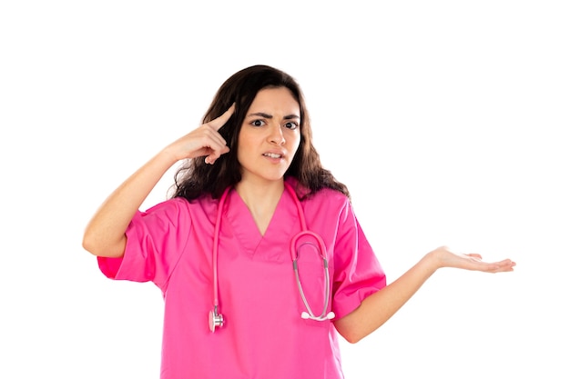 白い壁に分離されたピンクの制服を着た若い医者
