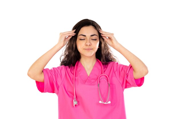 Young doctor with pink uniform isolated on a white wall