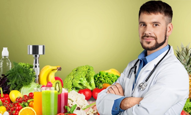 Young doctor with stethoscope on fruits background