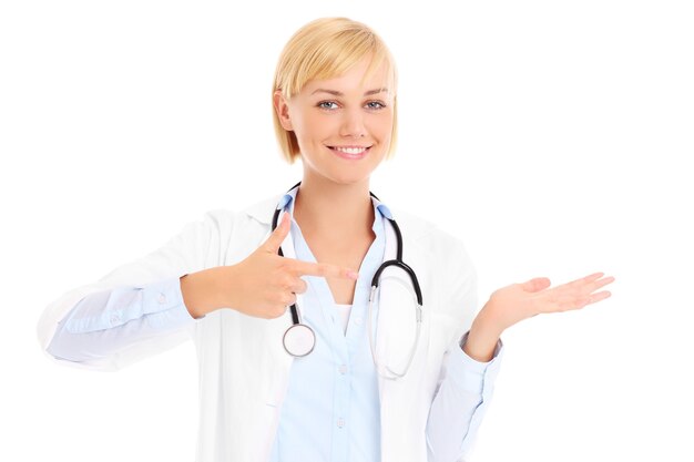 a young doctor with stethoscope showing something over white background