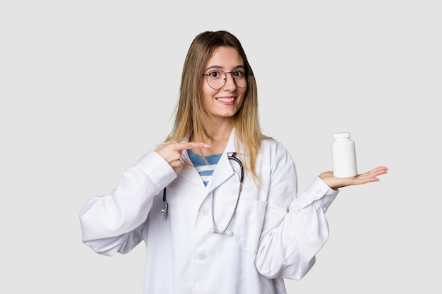 Young doctor woman holding pills isolated