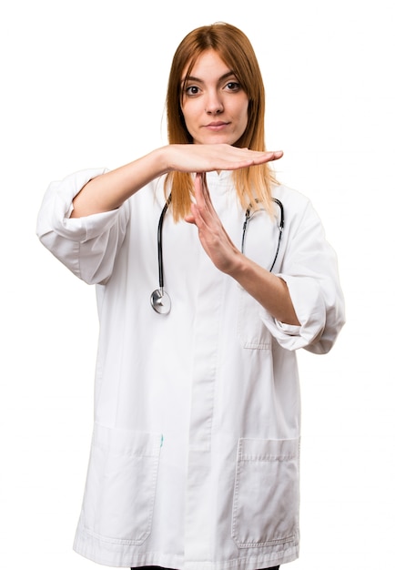 Young doctor woman making time out gesture