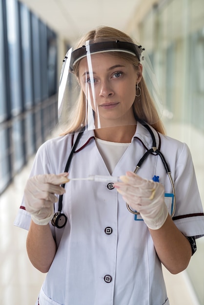 Молодая женщина-врач в белом халате идет сдавать анализ на covid. Концепция медицины