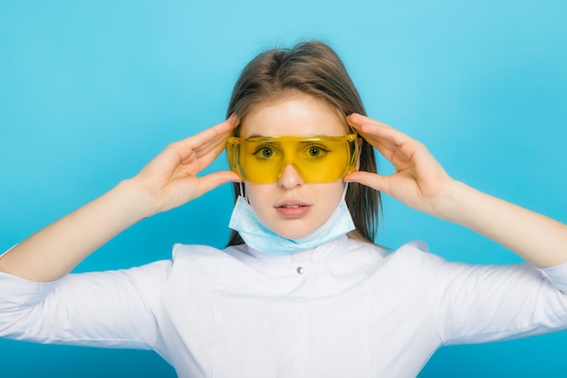 Young doctor woman with syringe and yellow glasses