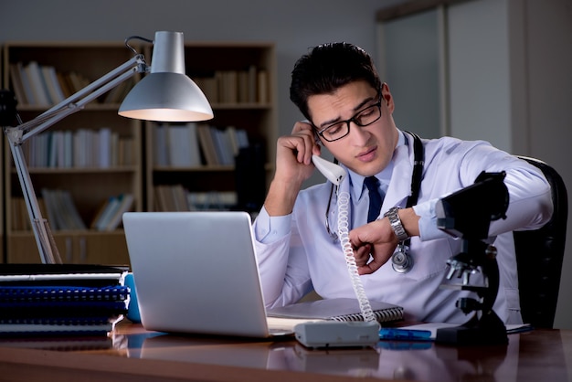 Photo young doctor working late in the office