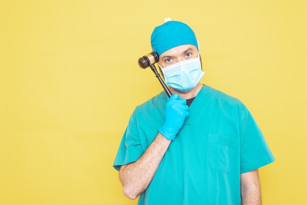 Young doctorsurgeon dressed in green on yellow background