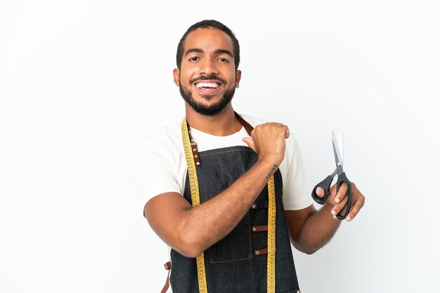 Young Ecuadorian design man holding scissors isolated on white background proud and self-satisfied