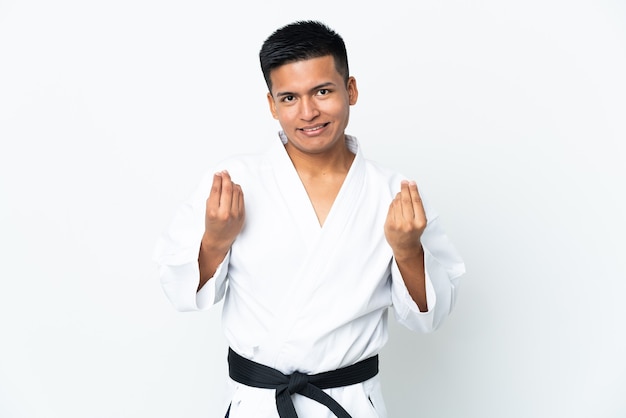 Giovane uomo ecuadoriano che fa karate isolato su sfondo bianco che fa soldi gesture