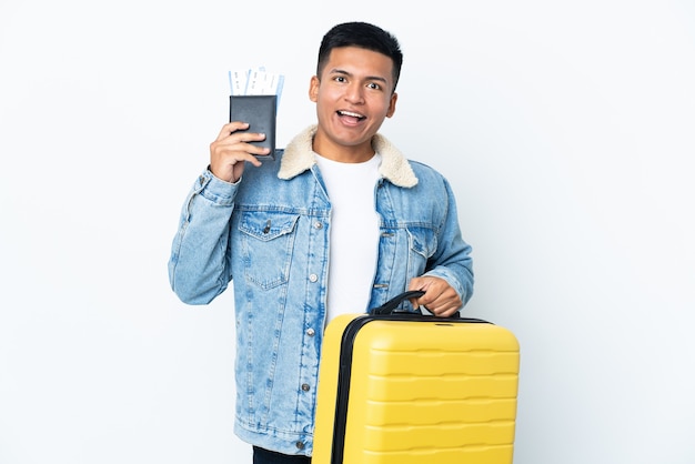 Young Ecuadorian man isolated in vacation with suitcase and passport