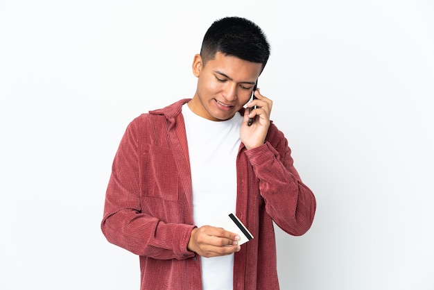 Young Ecuadorian man isolated on white background buying with the mobile with a credit card