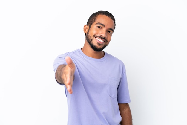 Young Ecuadorian man isolated on white background shaking hands for closing a good deal