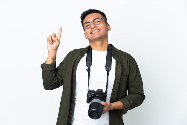 Young Ecuadorian photographer isolated on white wall pointing up a great idea