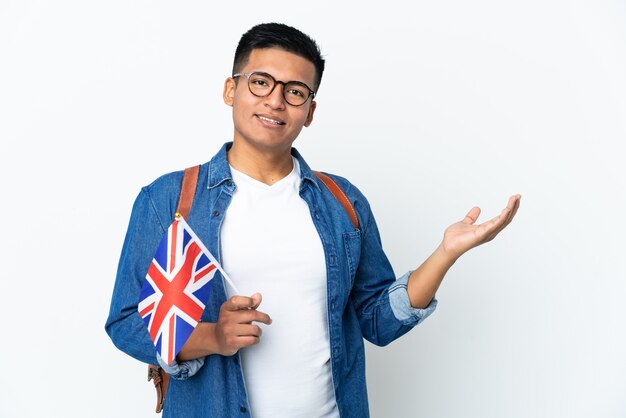 来るように誘うために手を横に伸ばして白い背景で隔離のイギリスの旗を保持している若いエクアドルの女性