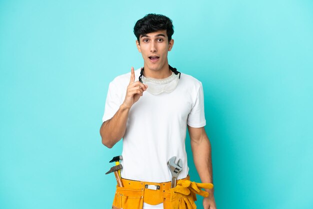 Young electrician Argentinian man isolated on blue background intending to realizes the solution while lifting a finger up