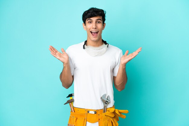 Young electrician Argentinian man isolated on blue background with shocked facial expression