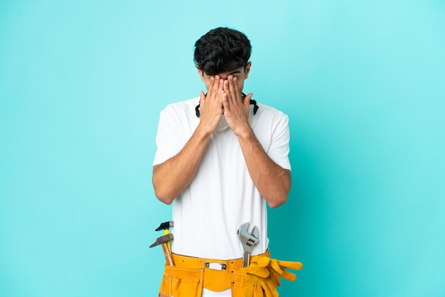 Young electrician Argentinian man isolated on blue background with tired and sick expression