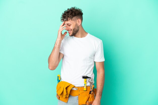 Young electrician blonde man isolated on green background laughing