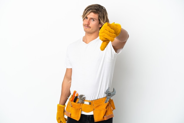 Young electrician blonde man isolated on white wall showing thumb down with negative expression