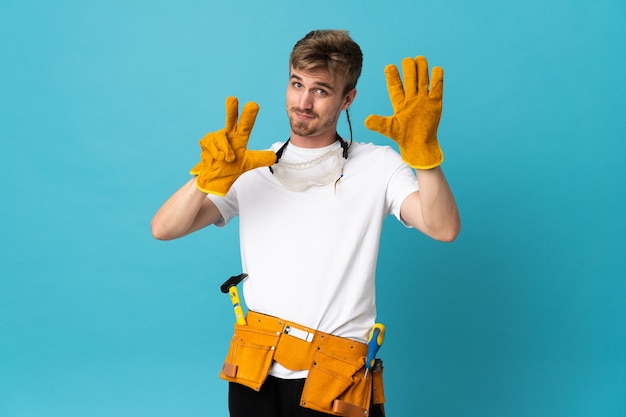 Young electrician man over isolated wall counting eight with fingers