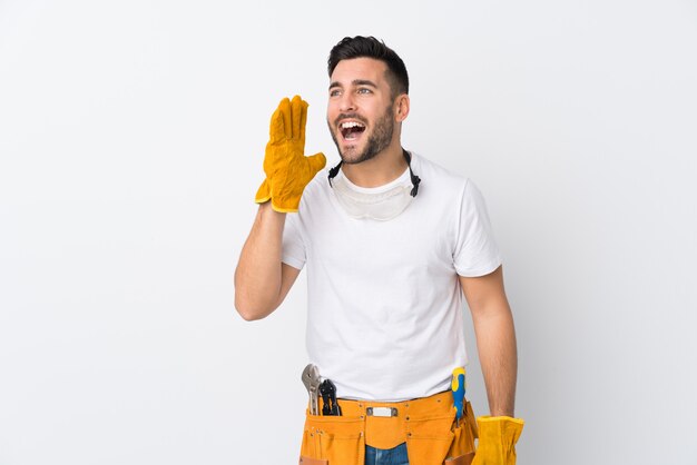 Young electrician man over isolated wall