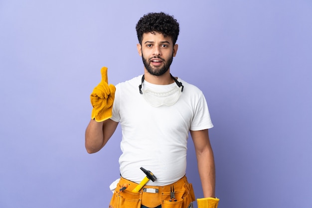 Young electrician Moroccan man isolated on purple background thinking an idea pointing the finger up